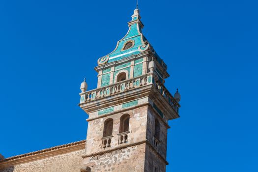 Beautiful view. Tower of the Monastery of Valldemossa in the Sierra de Tramuntana Mountains with park.