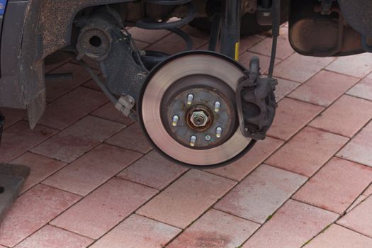 Disk brake on a car here Mechanic at the car brake repair in a car service workshop
