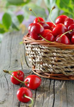 ripe cherries in a basket on wooden table