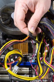 The photo shows a man repairing a computer