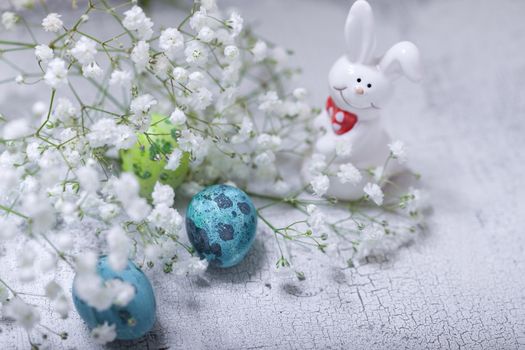 Eggs Rabbit and flowers on white surface. Easter symbols