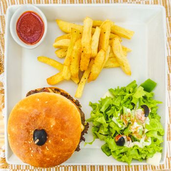 Burger served with salad, chips and tomato ketchup