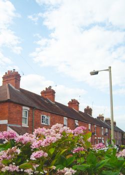 Retro Style Image Of Average British Terraced Street With Flowers In The Foreground And Copy Space