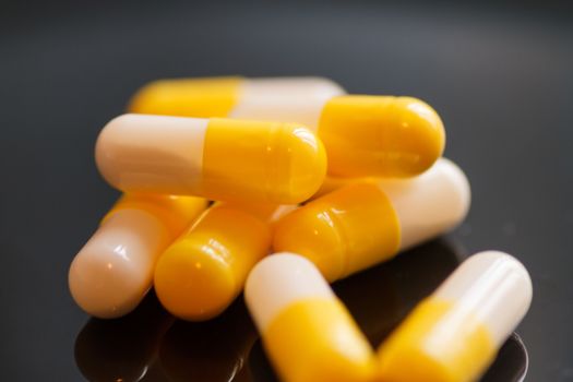 Yellow-white capsules on a dark background close-up