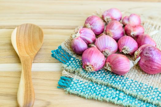 Shallot on sack on wooden table