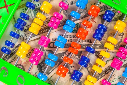 american dollars banknotes by the side of a colorful abacus