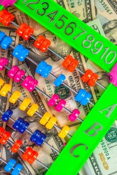 american dollars banknotes by the side of a colorful abacus