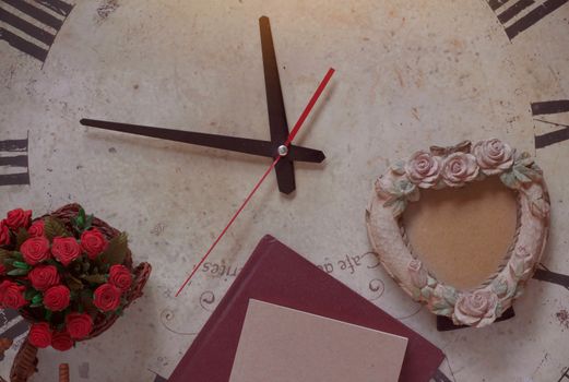 Book and photo frame on old antique clock.