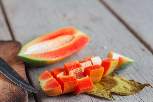 Cut the papaya on the old wooden floor.