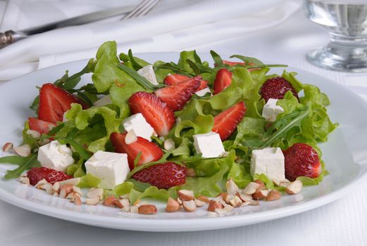 Salad of lettuce, arugula, strawberries, feta cheese and peanuts