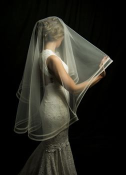 Portrait of a beautiful girl in image of the bride. Photo shot in the Studio on a black background