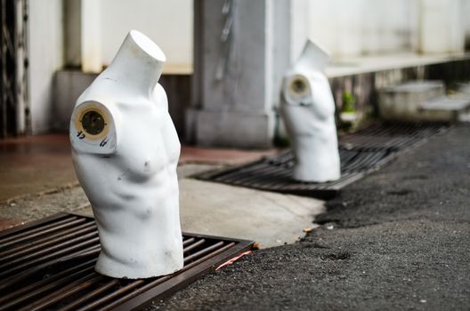 Torso male mannequin stand on the street near gutters