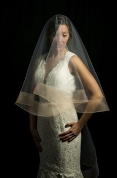 Portrait of a beautiful girl in image of the bride. Photo shot in the Studio on a black background