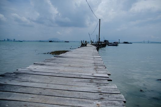 Wooden pier on the sea background, destroyed bridge near tropics. Color panorama