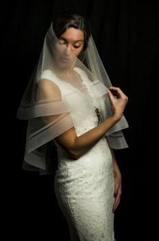 Portrait of a beautiful girl in image of the bride. Photo shot in the Studio on a black background