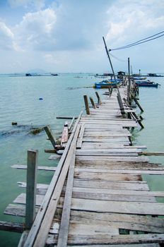 Wooden pier on the sea background, destroyed bridge near tropics. Color panorama