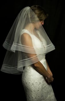 Portrait of a beautiful girl in image of the bride. Photo shot in the Studio on a black background