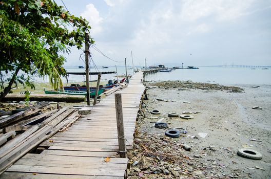 Wooden pier on the sea background, destroyed bridge near tropics. Color panorama