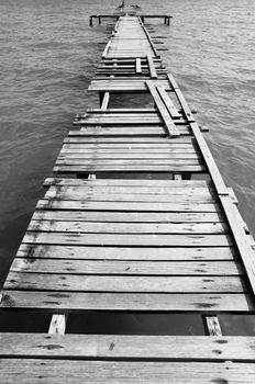 Penang island Malaysia. Wooden pier on the sea background, destroyed bridge near tropics. Black and white panorama