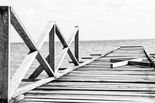 Penang island Malaysia. Wooden pier on the sea background, destroyed bridge near tropics. Black and white panorama