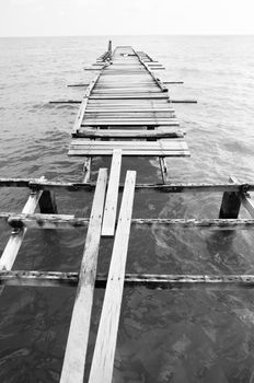 Penang island Malaysia. Wooden pier on the sea background, destroyed bridge near tropics. Black and white panorama