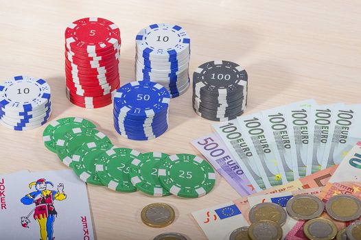 Multi-colored casino chips and money won on the game of gambling