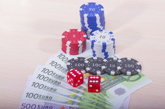 Multi-colored casino chips and money won on the game of gambling