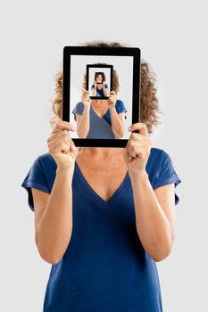 Woman holding a tablet and cover her face