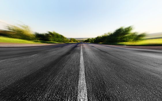 asphalt road through the green field in summer day