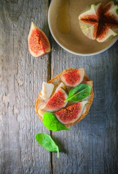 Sandwich with soft cheese and figs on a wooden surface