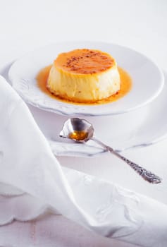 Creme Caramel on a white plate served on a table