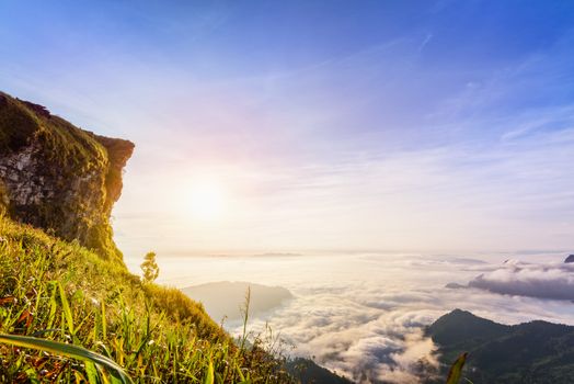 Beautiful landscape nature of sunrise on peak mountain with sun cloud fog and bright colors of sky in winter at Phu Chi Fa Forest Park is a famous tourist attraction of Chiang Rai Province, Thailand