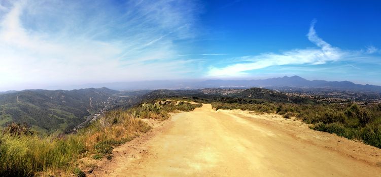 Hiking trail at the Top of the World in Laguna Beach that has a view of Saddleback Mountains and the canyon road below.