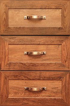 detail of decorated furniture drawers. old drawer - damper. Close-up detail of high quality Oak wood cabinets with bronze cabinet hardware drawer pulls