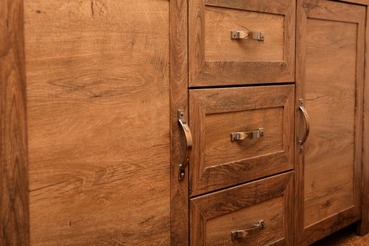 detail of decorated furniture drawers. old drawer - damper. Close-up detail of high quality Oak wood cabinets with bronze cabinet hardware drawer pulls