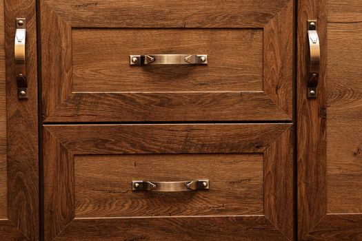 detail of decorated furniture drawers. old drawer - damper. Close-up detail of high quality Oak wood cabinets with bronze cabinet hardware drawer pulls