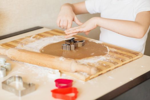 Master class for children on baking christmas cookies. Young children learn to cook a honey-cake. Kids preparing homemade gingerbread. Little cook.