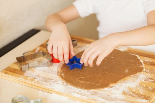 Master class for children on baking christmas cookies. Young children learn to cook a honey-cake. Kids preparing homemade gingerbread. Little cook.