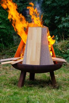 a burning Laminate panels in open fire on a grill place