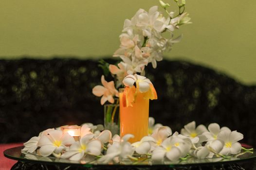 a freshly squeezed fresh orange juice, close-up with a Magnolia blossoms on the glas