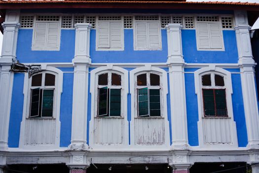 Penang, Malaysia. Color architecture narrow streets with people. Dirty moldy humidity cityscape