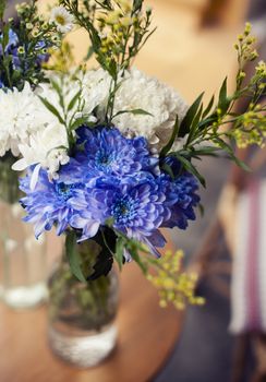 A simple bouquet of flowers in a vase on the pavement close up