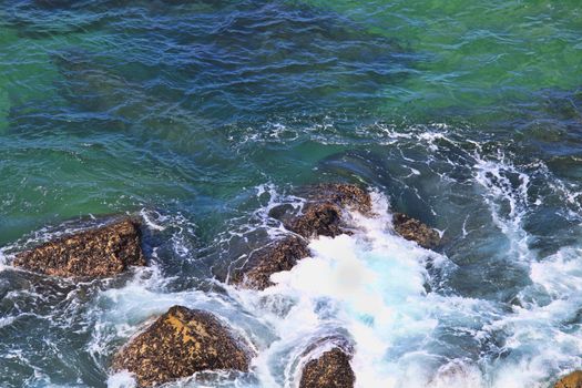 Marine wave breaks against offshore stone