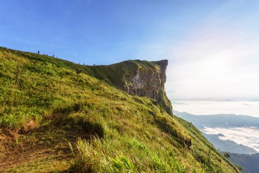 Beautiful landscape nature in morning on peak mountain with sun cloud fog and bright blue sky in winter at Phu Chi Fa Forest Park is a famous tourist attraction of Chiang Rai Province, Thailand