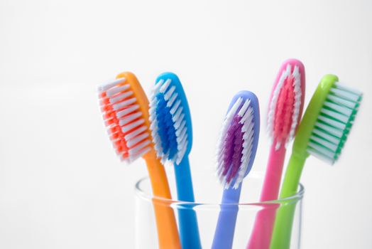 colorful toothbrushes in glass