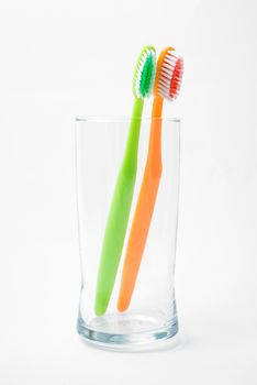toothbrushes in glass isolated on white
