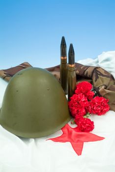 Flowers and army equipment on a studio background