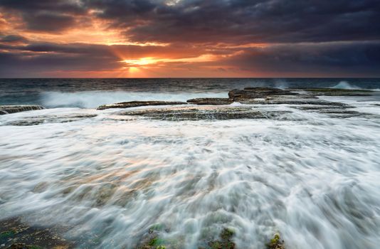 Tidal flows along the rockshelf  as runrays streak the sky