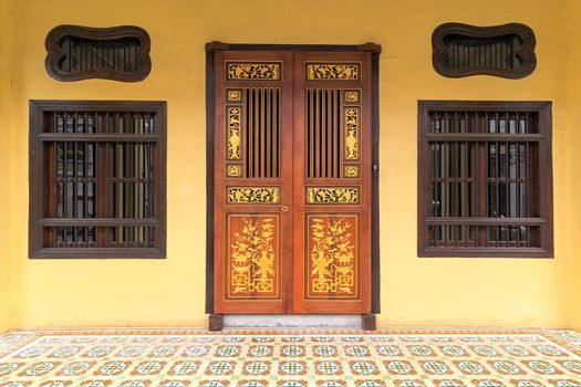 Peranakan typical style windows and ornate entrance doors an floor tiles in Penang Malaysia