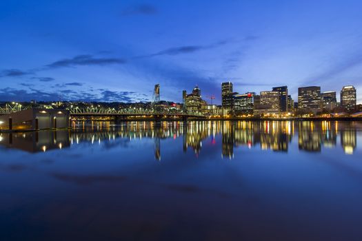 Portland Oregon downtown city skyline by Hawthorne Bridge over Willamette River waterfront during evening blue hour